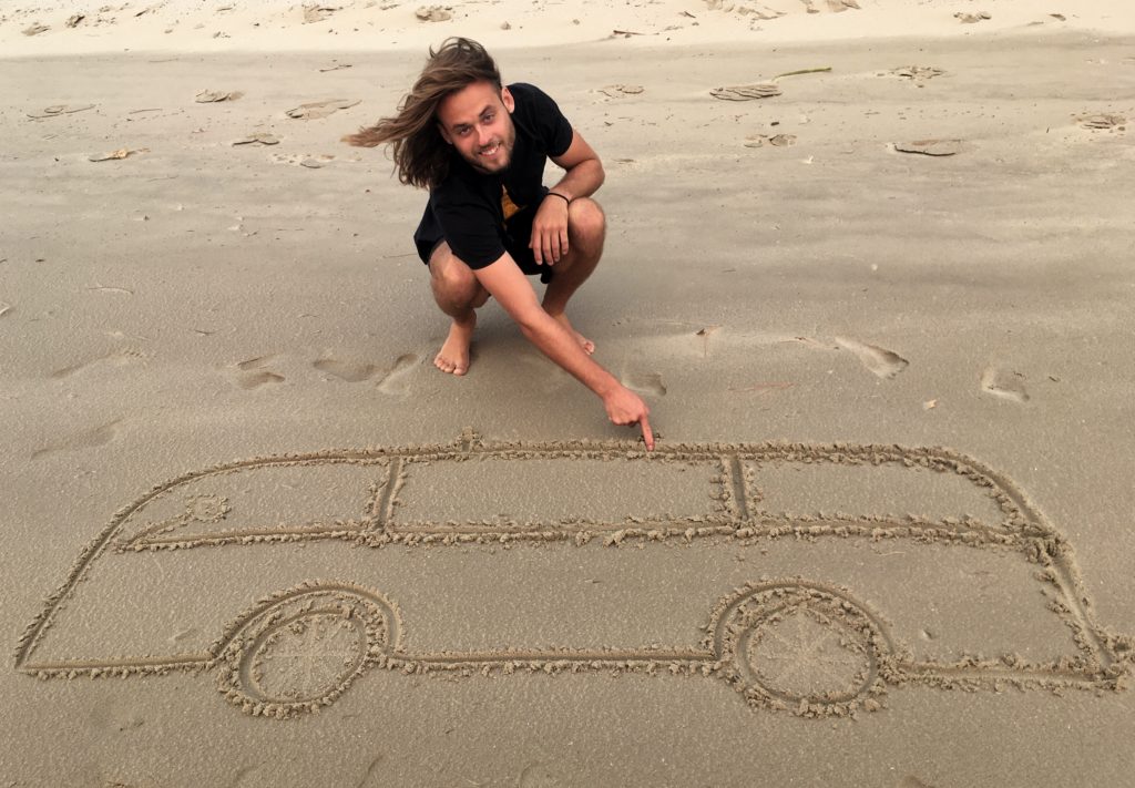 Adam do písku nakreslil svůj sen - obytné auto.